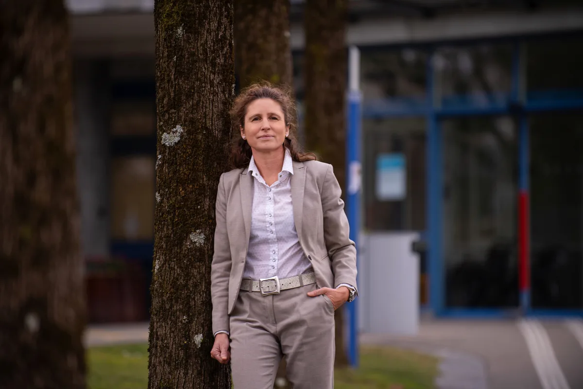 Eine Frau vor einem Baum. 